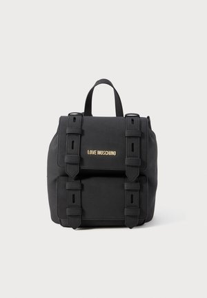Schwarzer Moschino-Rucksack mit doppelten Schnallenriemen, Vordertasche mit Klappe und Tragegriff oben vor weißem Hintergrund.