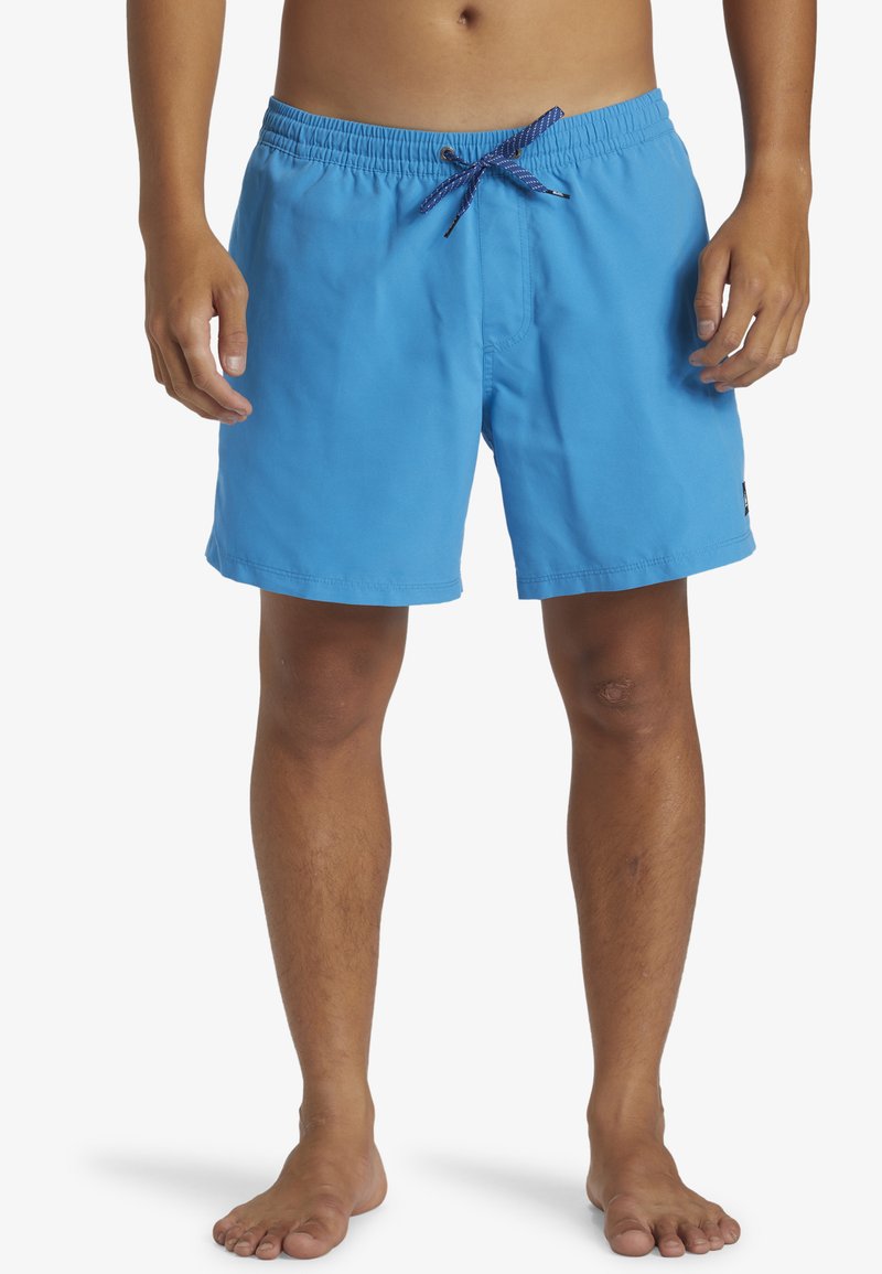 Bañador azul con cintura elástica, cordón ajustable y parte delantera plana. El material parece suave y ligero.