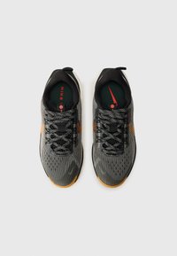 Black and gray running shoes with a textured knit upper, contrasting orange swoosh, black laces, and a rubber sole.
