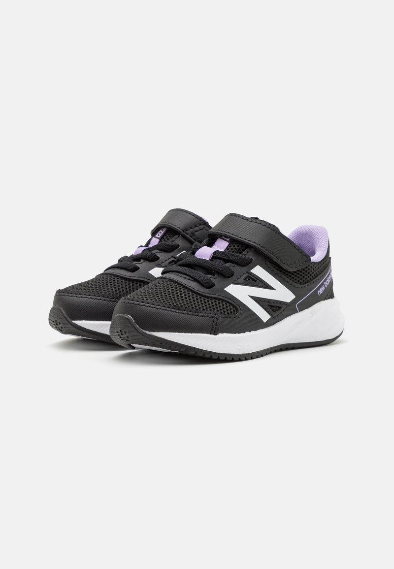Zapatillas deportivas negras con material de malla, acentos en blanco y detalles en lavanda. Cuentan con una suela acolchada y una correa con gancho y bucle para un ajuste seguro.