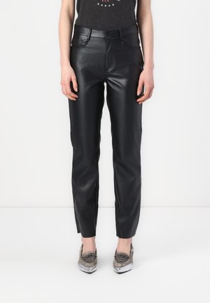 Zwarte neplederen broek met een slim-fit ontwerp, voorzien van voorzakken en een soepele textuur, gecombineerd met schoenen met metallic details.