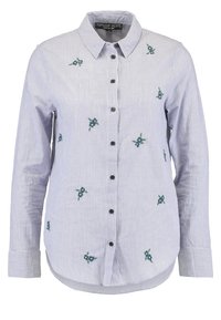 Pruhovaná modrá a bílá košile s dlouhými rukávy, zdobená květinovou výšivkou v zelené a modré barvě, a černými knoflíky vpředu.