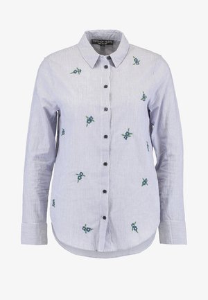 Gestreepte blauwe en witte overhemd met lange mouwen, voorzien van bloemenborduurwerk in groen en blauw, en zwarte knopen aan de voorkant.