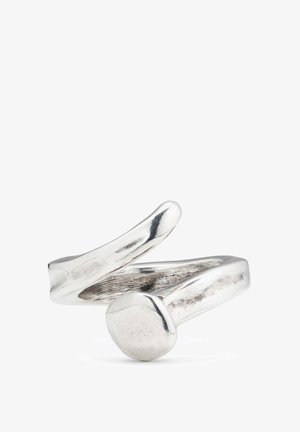 Anillo de plata con un diseño retorcido, con una punta suave y redondeada, y un acento circular. El metal tiene una superficie pulida y reflectante.