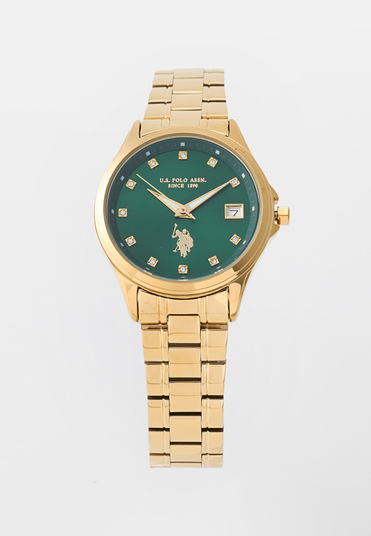 Goldfarbener Metallarmbanduhr mit grünem Zifferblatt, diamantähnlichen Stundenmarkierungen und dem Logo von U.S. Polo Assn. Verfügt über ein Datumsfenster und ein verlinktes Armband.