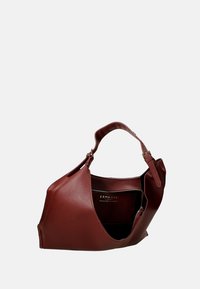Borsa in pelle bordeaux con una forma morbidamente svasata, manico superiore e un interno aperto che mette in mostra una tasca con zip. Esterno texturizzato con hardware minimal.