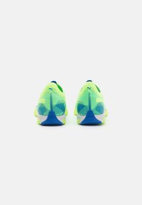 Scarpe da corsa gialle neon con tomaia in mesh testurizzato, dettagli blu sul tallone e sulla suola, e suola in gomma grigia.