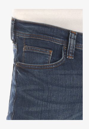 Jeans aus Denim in dunkler blauer Waschung mit orangefarbenen Nähten. Die Eigenschaften umfassen eine Vorderseite und eine kleine Münztasche über der Haupttasche.