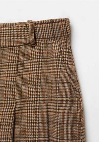 Broek gemaakt van gestructureerde bruine en beige stof met een houndstooth patroon, voorzien van een tailleband en zijzakken.