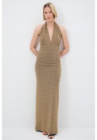 Robe dorée, longue jusqu'au sol, avec un décolleté halter et une taille définie. Le tissu a un léger éclat et une texture lisse.