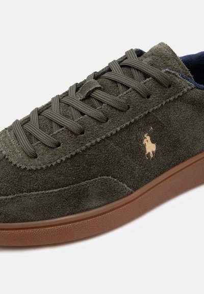Σκούρο πράσινο σουέντ αθλητικό παπούτσι με κορδόνια ίδιου χρώματος, καφέ λαστιχένια σόλα και μικρό χρυσό λογότυπο παίκτη πόλο στο πλάι.