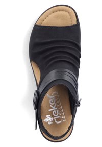 Sandale noire à bout ouvert avec dessus plissé, boucle latérale ajustable, et semelle intérieure rembourrée beige marquée "Rieker Antistress".