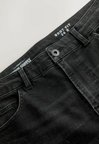 Sorte boot-fit jeans med knaplukning, der har en glat tekstur og en subtil vaskeffekt. Størrelsesmærkning: 34 R.