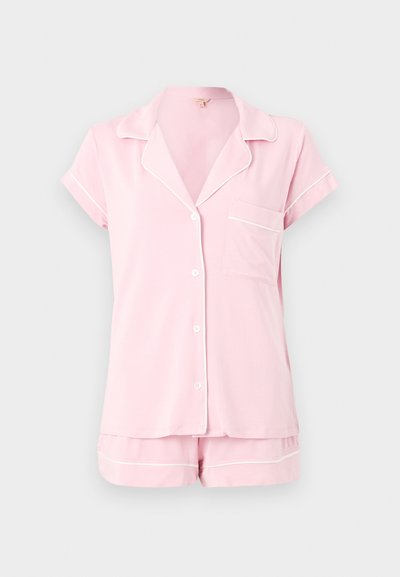 Ροζ ανοιχτό ροζ πυτζάμα με κοντά μανίκια, λευκές λεπτομέρειες και ταιριαστό σορτς σε μονόχρωμο φόντο.
