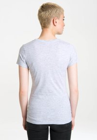 Grå kortærmet t-shirt med rund halsudskæring, lavet af blødt stof, med en tætsiddende design og en glat tekstur, iført med sorte bukser.