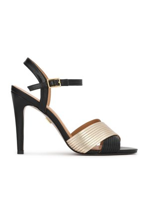 Schwarze High-Heel-Sandale mit Knöchelriemen und goldener Schnalle, mit breiten, überkreuzten Metallstreifen in Gold und Schwarz über den Zehen.