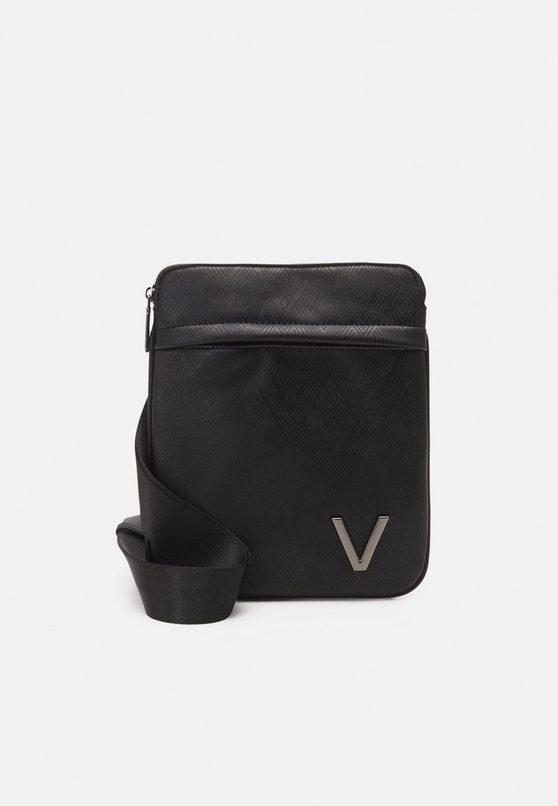 Black crossbody bag with a geometric pattern, smooth texture, and a metal "V" accent. Features a zip closure and a detachable strap.