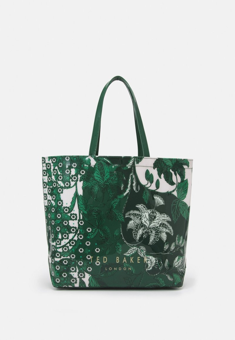 Sac cabas Ted Baker London à motif floral vert et blanc avec deux poignées sur fond uni.