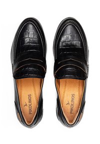 Mocasines de cuero negro con un patrón texturizado de cocodrilo, interior marrón y acentos de costura. Nombre de la marca "Pikolinos" visible en el interior.