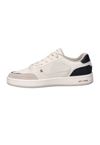 White low-top sneaker with beige suede toe, black heel patch, gold eyelets, and "EST. 1992" text on the sole side.