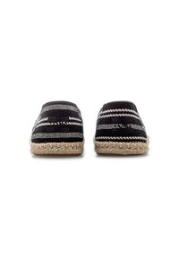 Black and white striped espadrilles with a woven fabric upper and jute rope sole, featuring a flat design and rounded toe.