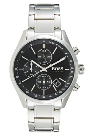 Montre-bracelet en métal argenté avec cadran noir, trois sous-cadrans, échelle tachymétrique, affichage de la date et la marque BOSS Hugo Boss.