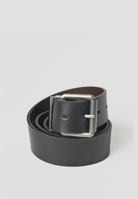 Cinturón de cuero negro enrollado con una hebilla rectangular plateada, sobre un fondo liso de color gris claro.