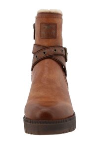 Bottine en cuir marron avec une finition texturée, dotée d'une bordure en fausse fourrure, d'une sangle réglable et d'œillets décoratifs en métal.