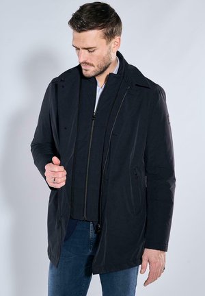 Navy nylon jacket with zippered front, stand-up collar, and side pockets. Features a quilted interior and a sleek, modern cut.