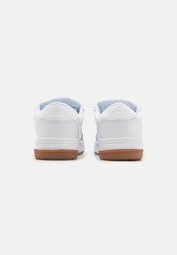Zapatillas de cuero blancas con una franja azul claro, que presentan una suela de goma texturizada y un collar acolchado para mayor comodidad.