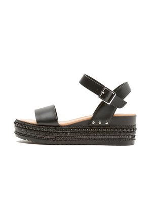 Sandali piattaforma neri con una larga fascia frontale e una cinghia alla caviglia regolabile, caratterizzati da decorativi perline lungo la suola e dettagli testurizzati.
