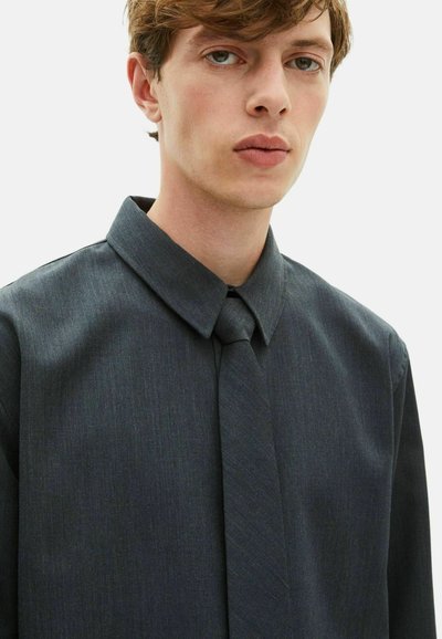 Dunkelgraues Hemd mit Knopfverschluss und strukturiertem Kragen sowie passender Krawatte; besitzt ein dezentes, strukturiertes Muster und einen glatten Stoffoberfläche.