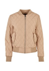 Veste bomber matelassée beige avec col, poignets et bas côtelés, fermeture éclair à l'avant et poches à rabat pressionnées des deux côtés.
