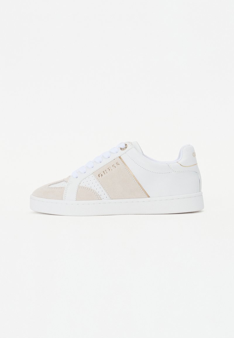 Vita sneakers med suède detaljer i beige, perforerade inslag, platta snören och en gyllene logotyp på sidan. Slät textur, lågt skaft.
