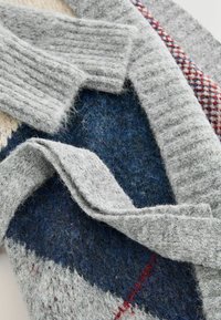 Gray knitted cardigan featuring a textured fabric with ribbed cuffs, complemented by blue and white patterns, and a smooth overall finish.