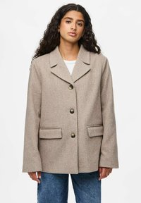 Beige villasegu seguval mingitud jakker, millel on krae, kolme nupu kinnitusega, kaks esikut ja tekstureeritud kootud muster.