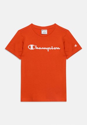 T-shirt orange à manches courtes avec le logo blanc "Champion" sur la poitrine et un petit logo sur la manche gauche, col rond.