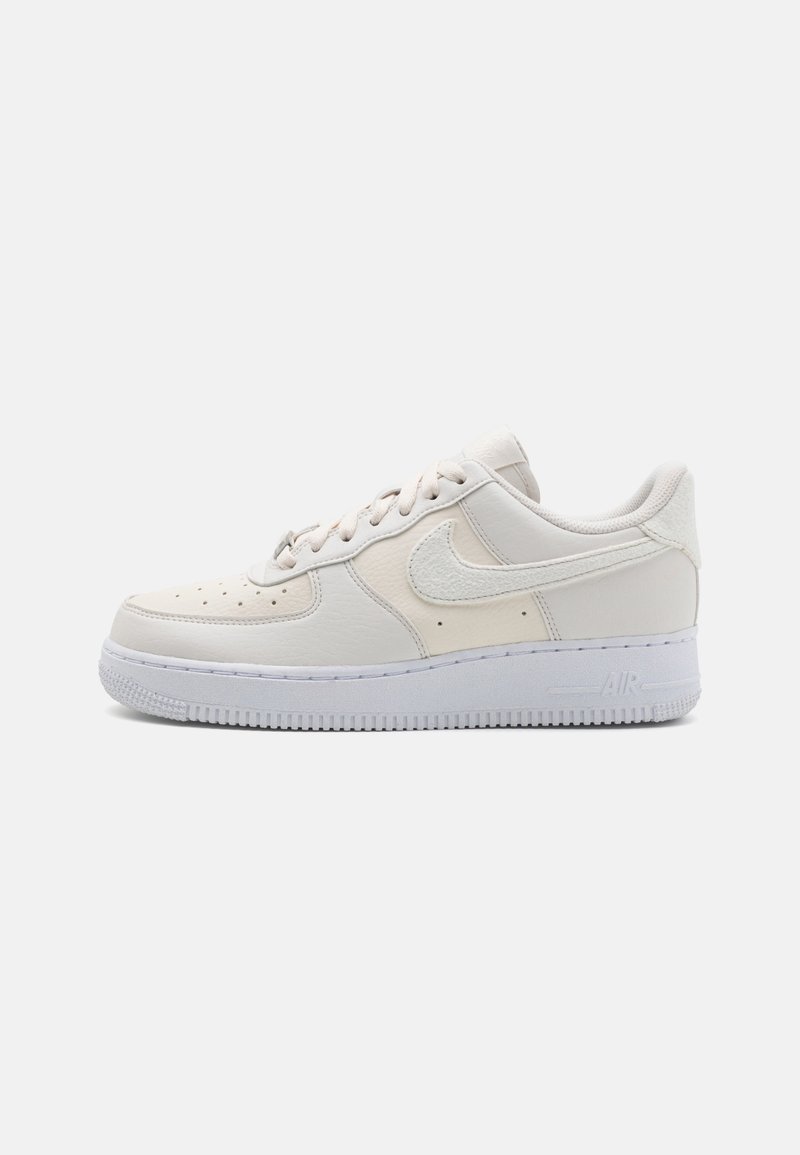 Baskets basses blanches Nike Air Force 1 avec dessus en cuir, perforations sur la boîte à orteils, logo swoosh cousu et semelle épaisse en caoutchouc.
