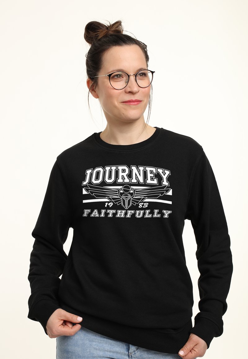 Zwarte sweatshirt met een grafische print met de tekst "JOURNEY 1983 FAITHFULLY." De stof is zacht, met ribgebreide manchetten en een ronde hals ontwerp.