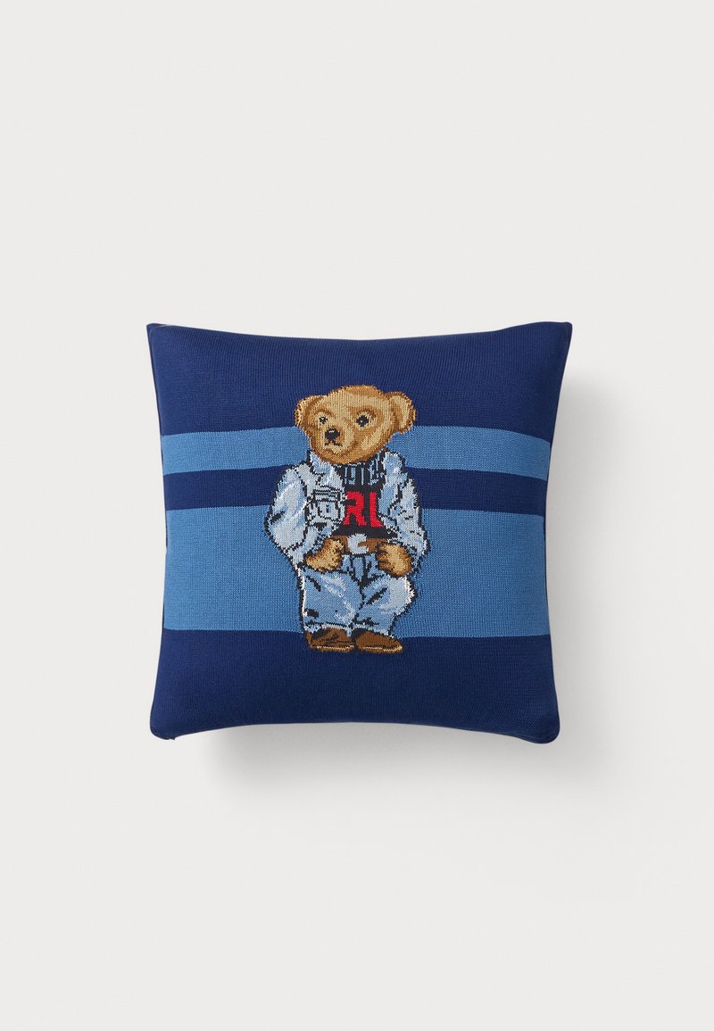 Polštář s námořnickými a světle modrými pruhy s designem medvídka v bundě a džínech, zdobený výšivkami a příjemným povrchem.