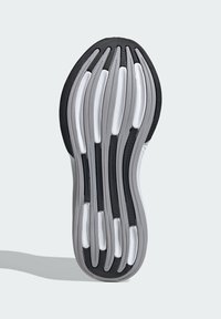 Suela de zapato en negro y gris con un diseño ondulado. Presenta múltiples surcos y patrones para una mejor tracción, fabricada en goma y material sintético.
