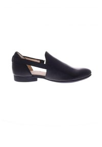 Zapato negro de piel tipo slip-on con punta afilada, cortes laterales y tacón bajo. Textura suave y diseño minimalista.