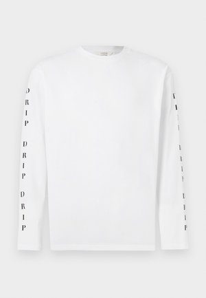 Chemise blanche à manches longues avec texte vertical noir "DRIP" répété le long des deux manches, col rond, devant et dos unis.