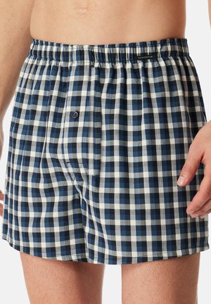 Shorts en coton de couleur bleu marine et à motif à carreaux blancs, dotés d'une taille élastique et d'une fermeture à bouton.