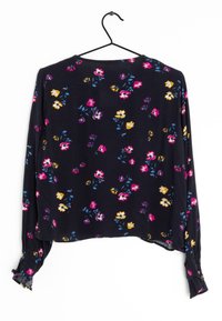 Langærmet sort bluse med blomsterprint præget af lyserøde, lilla og gule blomster, med en afslappet pasform og samlede manchetter på ærmerne.