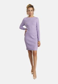 Completo a due pezzi ribbed in lilla, composto da un top a maniche lunghe e una gonna aderente. Tessuto liscio con una silhouette slim.