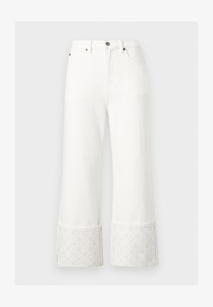 Biele džínsové nohavice so širokými nohavicami, s vysokým pásom a širokými manžetami, ktoré nesú jemný vyrazený geometrický vzor.