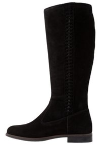 Botas altas de ante negro con tacón plano, parte superior suave y detalles trenzados a lo largo del lado para añadir textura y diseño.