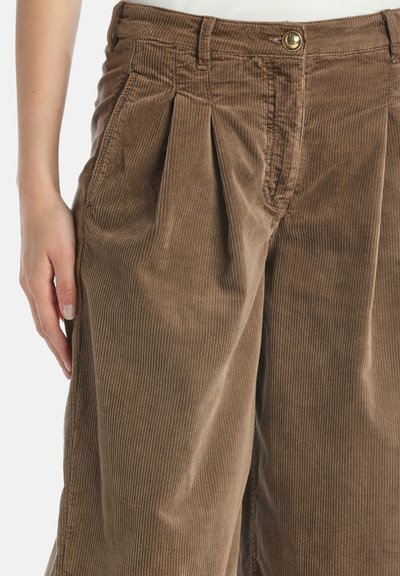 Bruine corduroy wijde broek met plooien aan de voorkant, een gouden knop en een gestructureerd ribbeloppervlak. Zakken aan de zijkanten zichtbaar bij de naden.