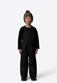 Black insulated overall with a zip front, worn over a textured black long-sleeve shirt. The child wears a patterned knit hat with pom-pom.